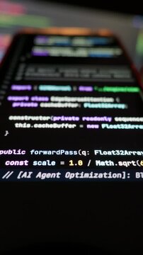 Program code syntax displays on an illuminated mobile screen during automatic vibe coding generation. Luminescent text against deep black offers striking modern tech production value.