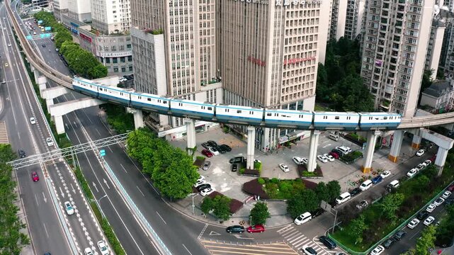 Aerial view of monorail train crossing urban intersection in Chongqing, China