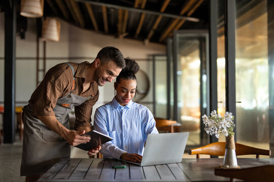 Professional business manager and restaurant owner discussing strategy on a digital tablet