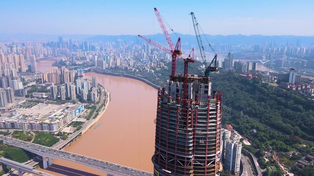 Aerial view of skyscraper under construction by river in Chongqing, China