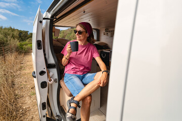 Senior woman drinking coffee inside camper van in Tarifa Spain © Paolo Corazza
