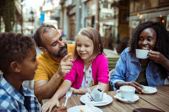 Man playfully teasing girl at outdoor cafe