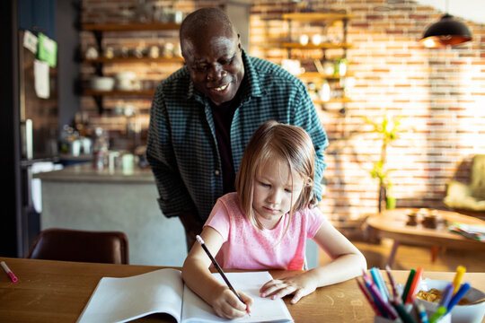 Man helping girl with homework at kitchen table