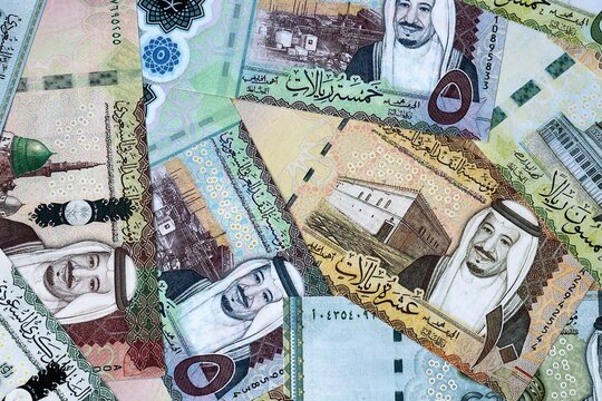 Saudi riyal money bills in pile on table. Saudi Arabia SAR currency banknotes background