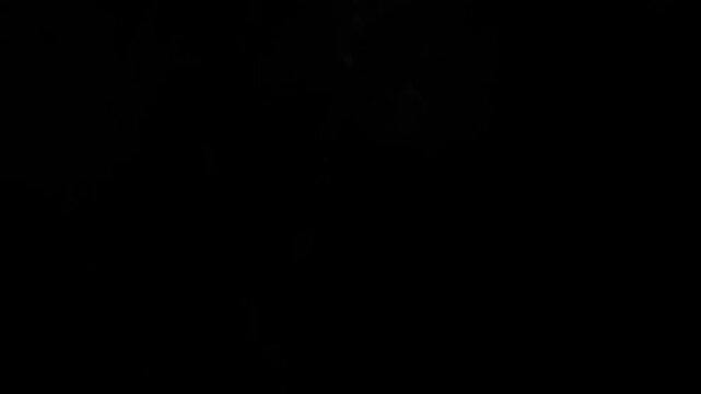 Dusty bullet hits on a wall with chunks of debris flying out . Powder explosion on black background. Impact dust particles. Dust explosion in front of black background, slow-motion close up. VFX
