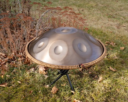 handpan drum on a stand outdoors, a modern, melodic percussion instrument made of steel, known for its soothing, resonant tones