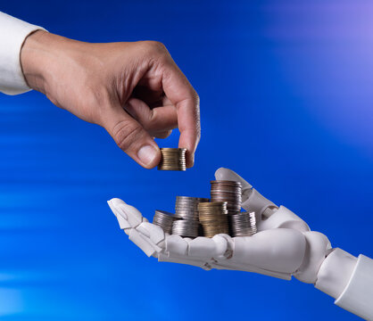 Human and AI Robot Hand Sharing Money Coins on Blue Background Concept