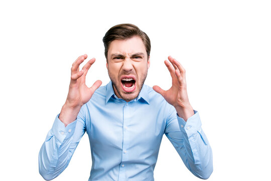 Portrait of very angry, annoyed, wild man shouting, yelling, holding hands near face, standing over grey background