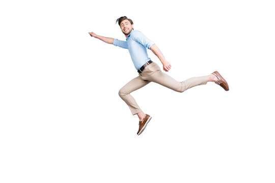 Happy, attractive, handsome, young man with bristle jumping in air showing superman pose looking at camera with beaming smile over grey background
