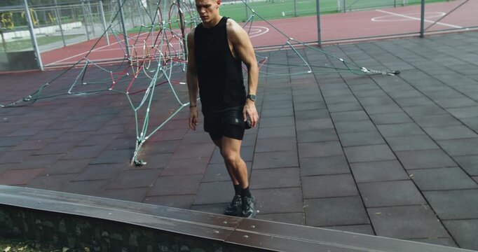 Athletic man training at sports court outdoors and doing side lunges exercise. Shirtless muscular male has workout at stadium. Fitness Sport Street Workout. Healthy Man On Pull-up Bars Exercising.