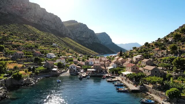 Coastal Mediterranean stone village in mountain bay at noon