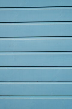 Blue painted wooden boards with clean horizontal lines and subtle wood grain