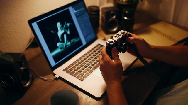 Professional photographer checking camera settings while editing photos on a laptop in a cozy home office, a creative workspace for remote work and digital photography