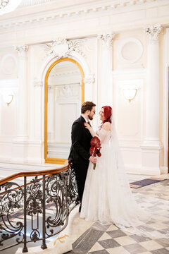 The bride and groom in a majestic hall.