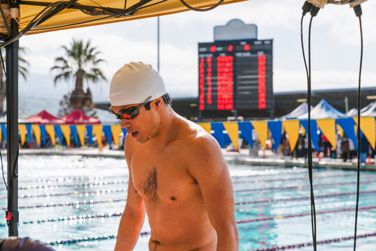 competitive swimmer on pool deck after race breathing heavy