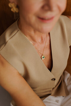 Woman wearing gold necklace with emerald gemstone