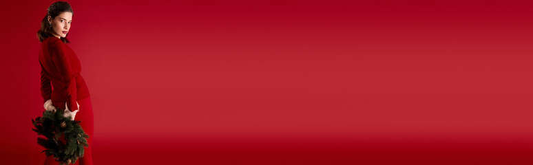 Obraz premium Young woman in stunning red dress embracing Christmas cheer