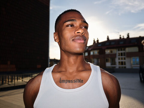 Determined young man with impossible tattoo looking ahead