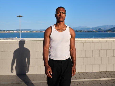 Young man standing confidently outdoors by sea