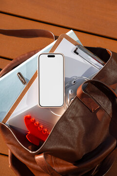 Smartphone mockup with blank white screen inside leather work bag