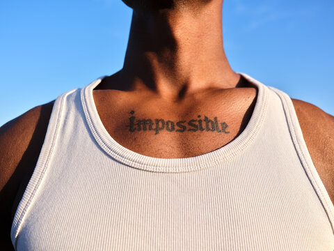 Person with impossible tattoo on chest showing ambition