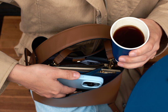 Anonymous woman takes the phone out of the bag.