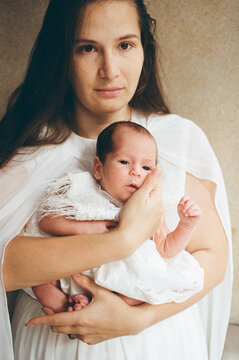Mother Holds Newborn Baby in Soft Light Setting
