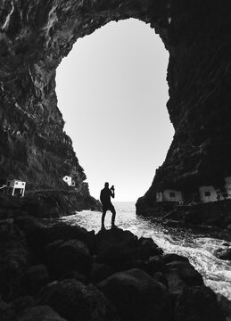 Silhouette photographer beneath sea cave at Por&Atilde;&shy;s de Candelaria