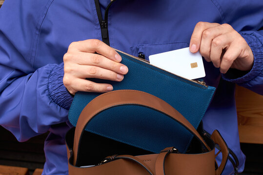 Woman takes blank credit card out of leather purse.