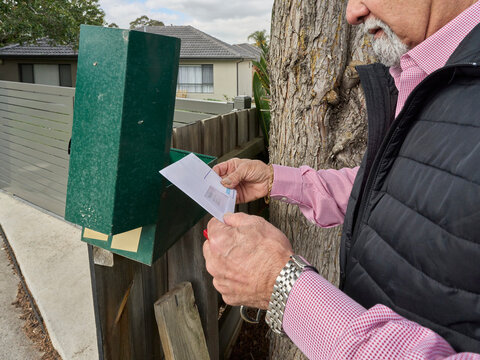Person Checking Mail at Mailbox Near House in Neighborhood