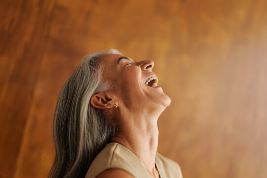Mature woman laughing with joy, expressing happiness and freedom