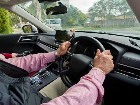 Driver Holds Steering Wheel in Car