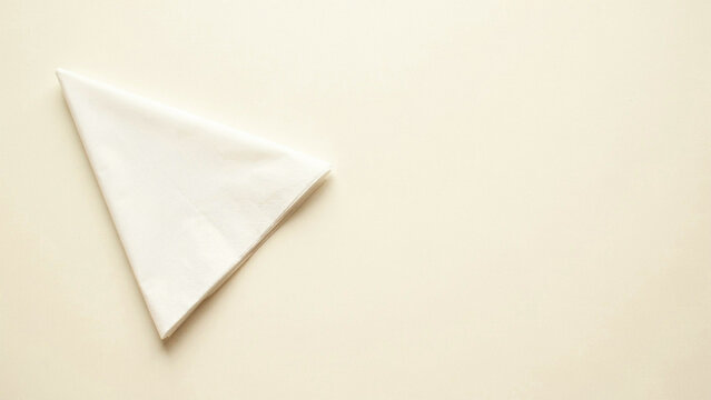 Single folded white paper napkin placed on a light beige background, with ample copy, space area