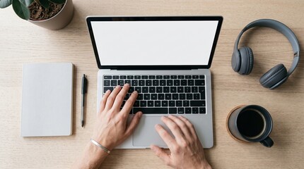 Fototapeta premium Hands type on a laptop with blank white screen beside headphones, coffee and notebook. Concept remote work and digital productivity for advertising, websites and blogs. Generative AI.