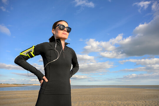 Woman in Fitness Gear on a Sandy Beach