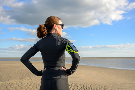 Woman in Sportswear on Sandy Beach Resting after Exercise