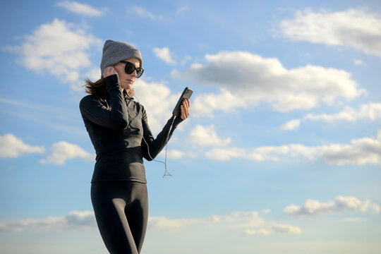 Woman in Winter Sportswear Checking Mobile Device