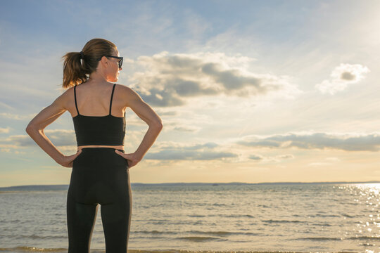 Woman in Sortswear Standing by the Sea