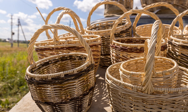 Woven baskets sit on wooden table outdoors