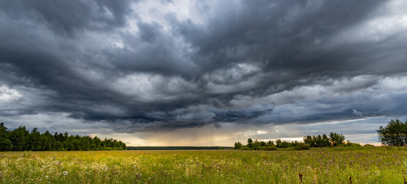 Dark clouds loom over open field