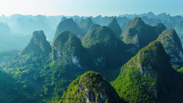High angle shot captures magnificent karst mountain peaks bathed in gentle morning sunlight near Xianggong Mountain in Guilin.