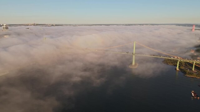 cinematic aerial footage of Halifax Harbour covered by low morning mist, with the fog rolling toward downtown and brushing against the city&rsquo;s high-rise buildings along the waterfront.