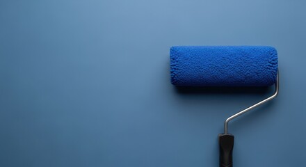 Obraz premium Blue paint roller with a textured foam head against a solid matte blue wall background surface