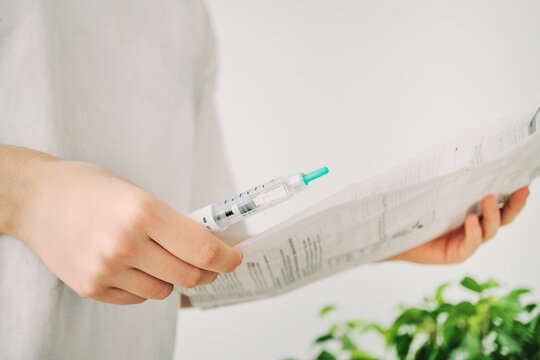 Woman reading instructions for using medical GLP-1 injector pen