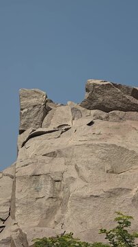 Vertical view of granite cliff and blue sky