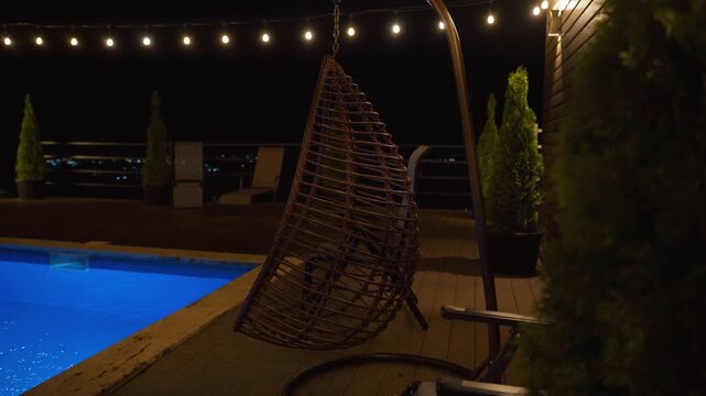 Luxurious private swimming pool glowing with vibrant blue lights in a tranquil backyard setting at night, with warm string lights creating a cozy and inviting atmosphere for relaxation or a party