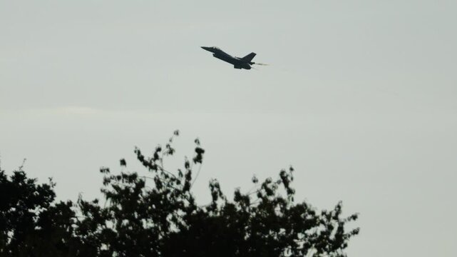 Military F16 fighter jet performing aerobatic maneuvers