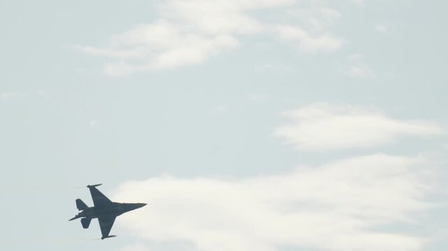 Military F16 jet fighter performing aerobatic maneuvers in the sky