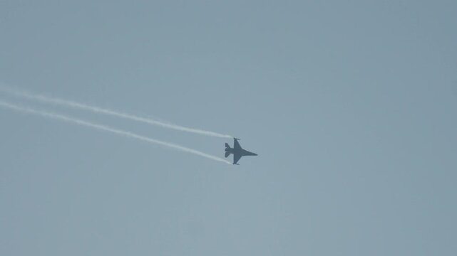 Military F16 fighter jet performing aerobatics at airshow