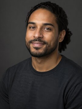 Portrait of bearded man with slight smile on gray background
